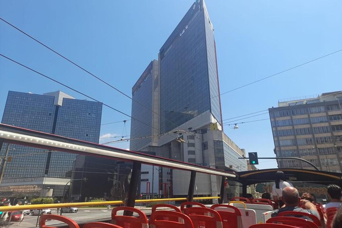 ένα λεωφορείο που κινείται σε έναν δρόμο της πόλης με ψηλά κτίρια