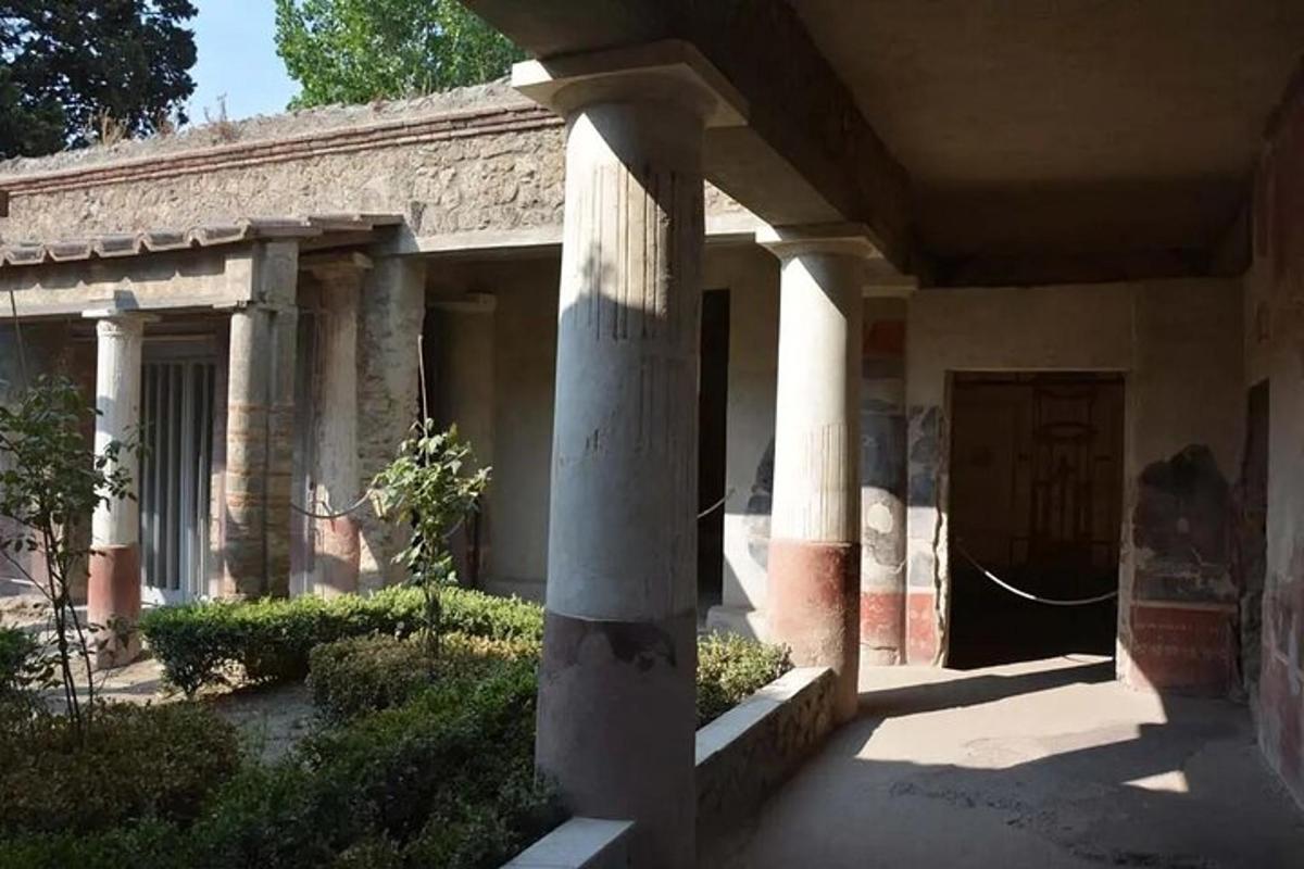sebuah bangunan dengan tiang dan pintu di halaman