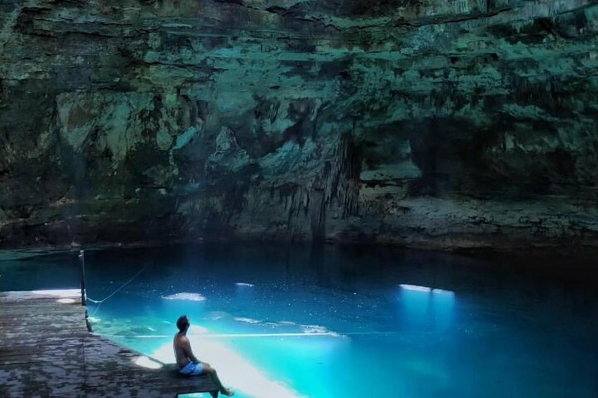 un home assegut en un bassal d'aigua en una cova