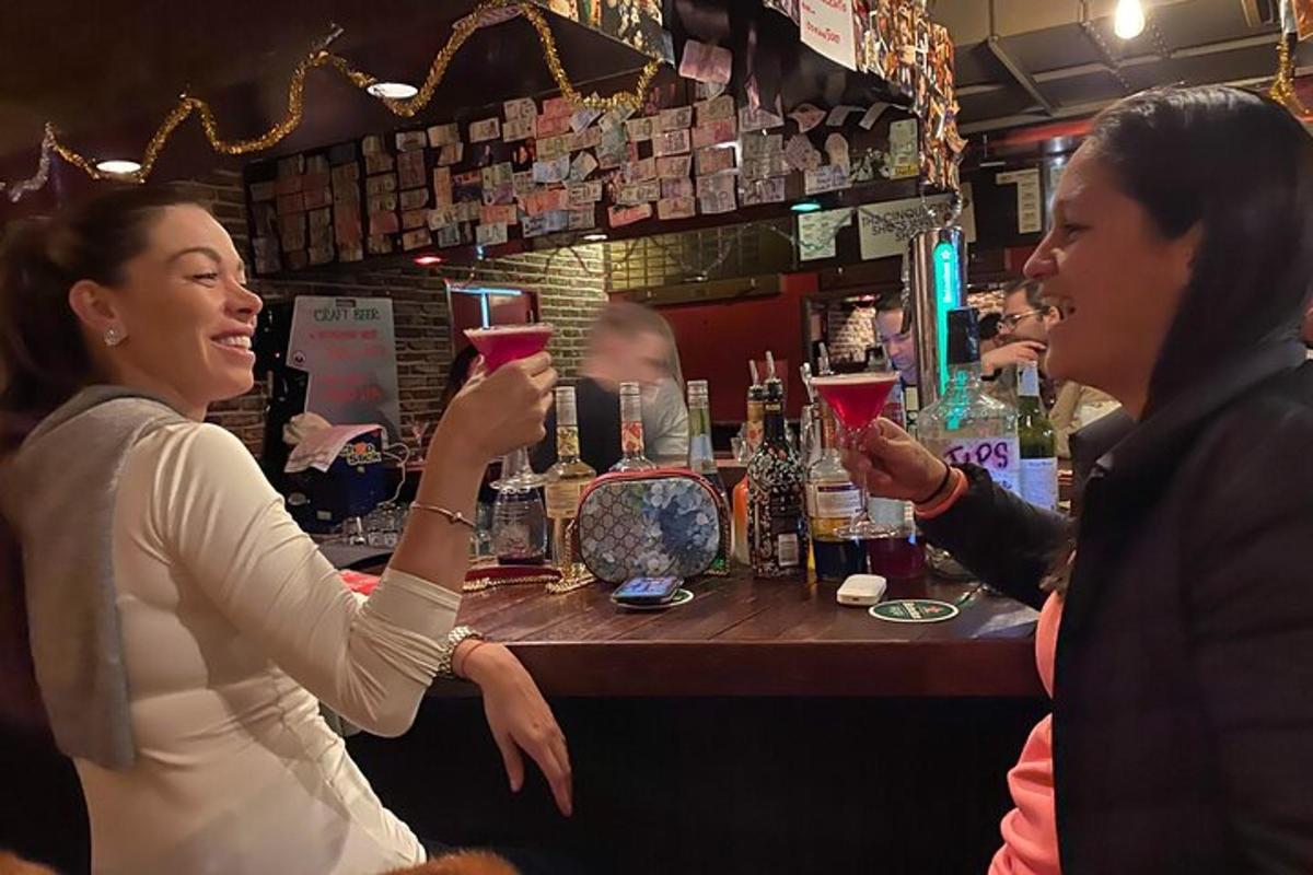 dues persones sostenint copes de vi en un bar
