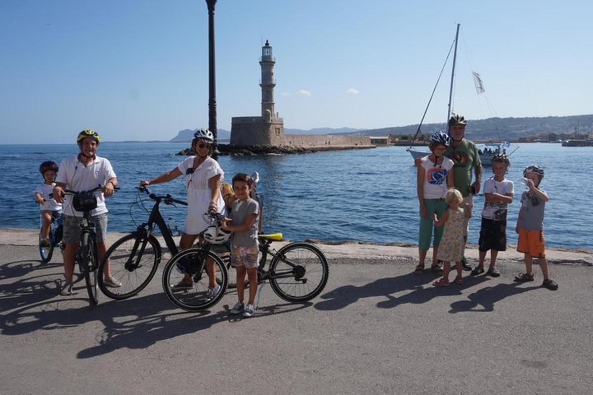 skupina ljudi, ki stojijo ob vodi s kolesi