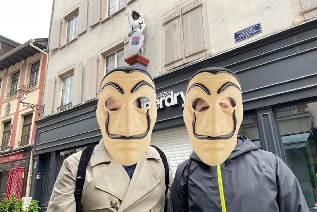 Δύο άτομα με μάσκες στα πρόσωπά τους μπροστά από ένα κτίριο