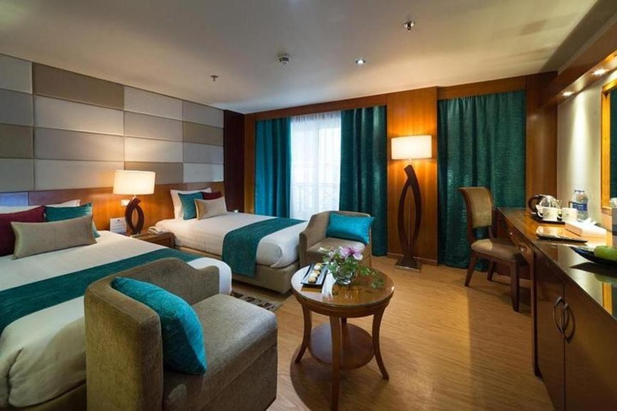 o cameră de hotel cu două paturi și o canapea