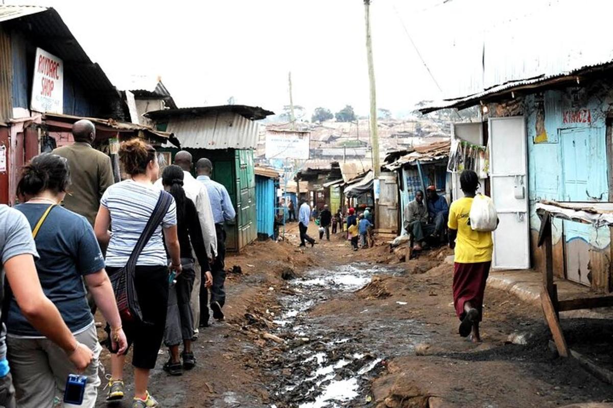 a group of people walking down a muddy street