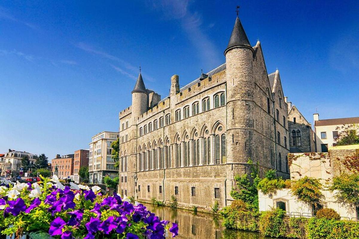 un grande edificio in mattoni con torri sul lato di un fiume