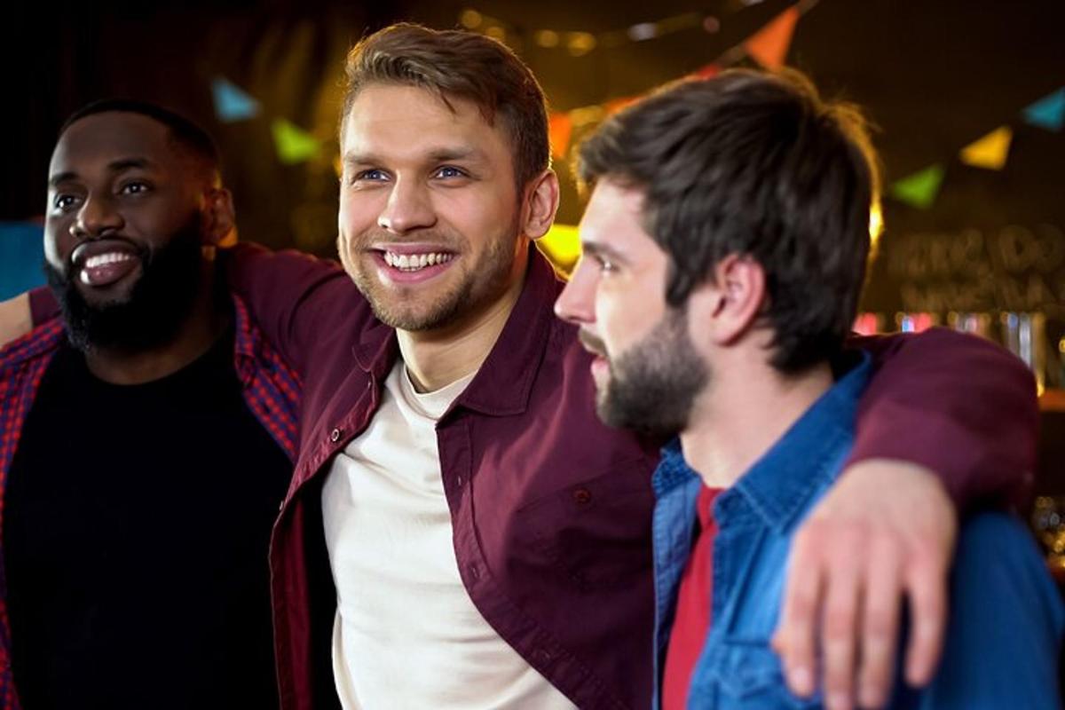 two men standing next to each other at a party
