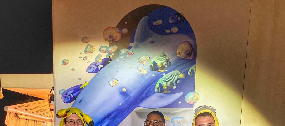 two people standing in front of a surfboard with a shark
