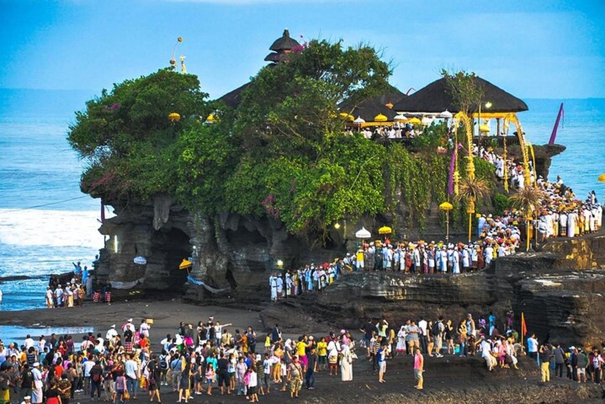 um grande grupo de pessoas em pé em uma praia perto do oceano