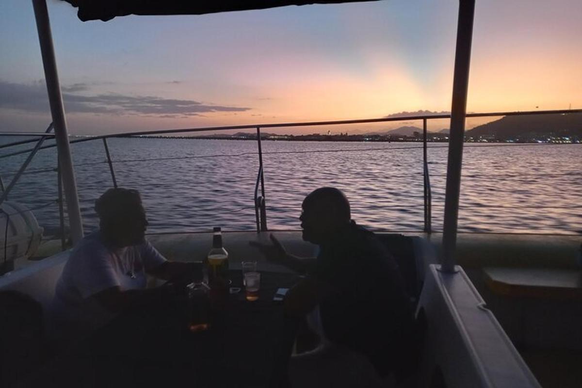 two people sitting at a table on a boat in the water