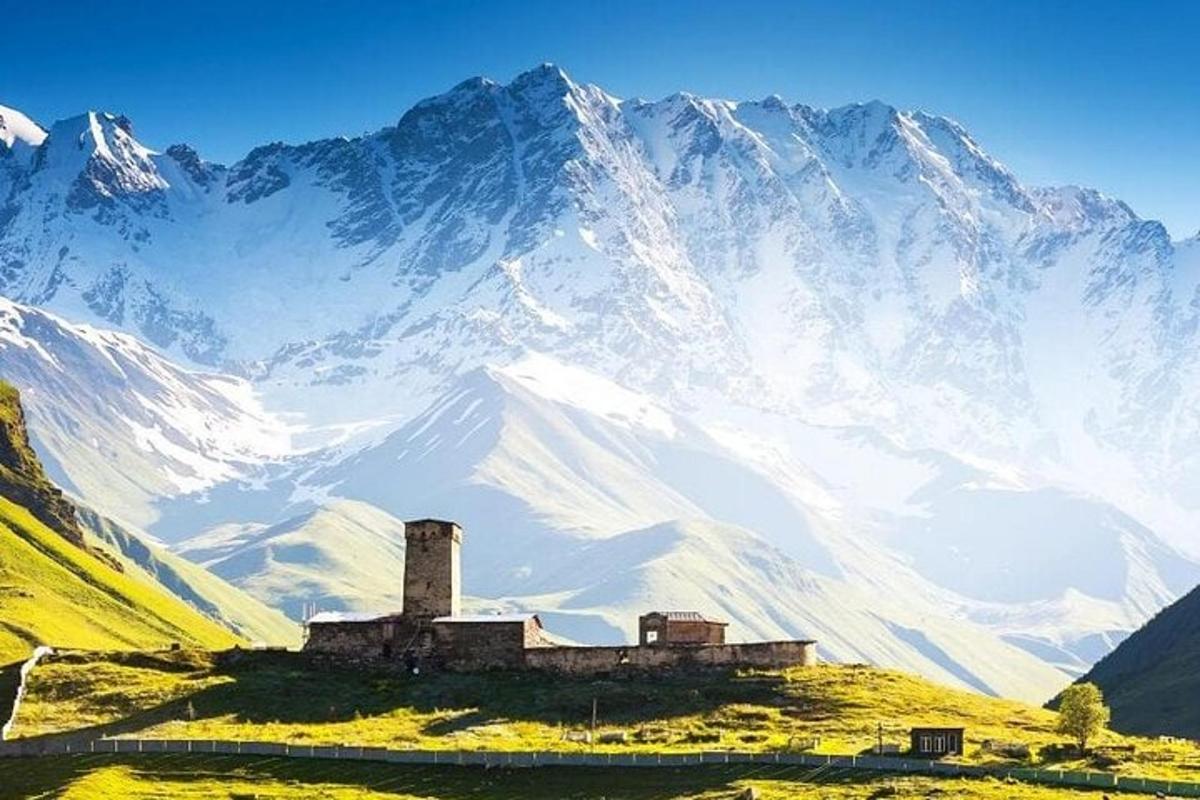 Un edificio antiguo en una colina frente a una montaña.