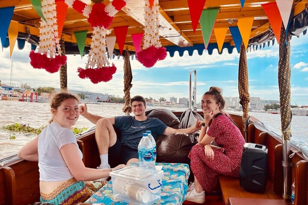 tre persone sedute sul retro di una barca