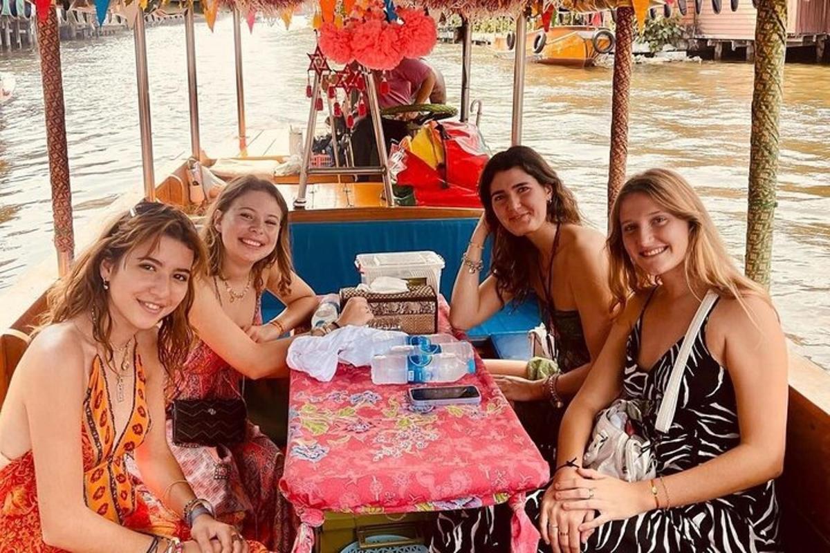 un gruppo di ragazze sedute su una barca con un tavolo