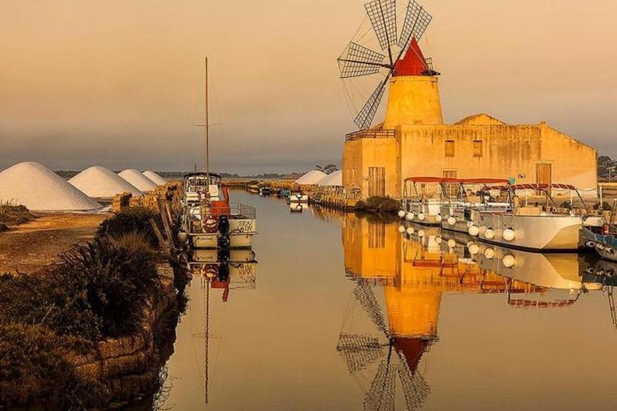a building with a windmill and boats in the water