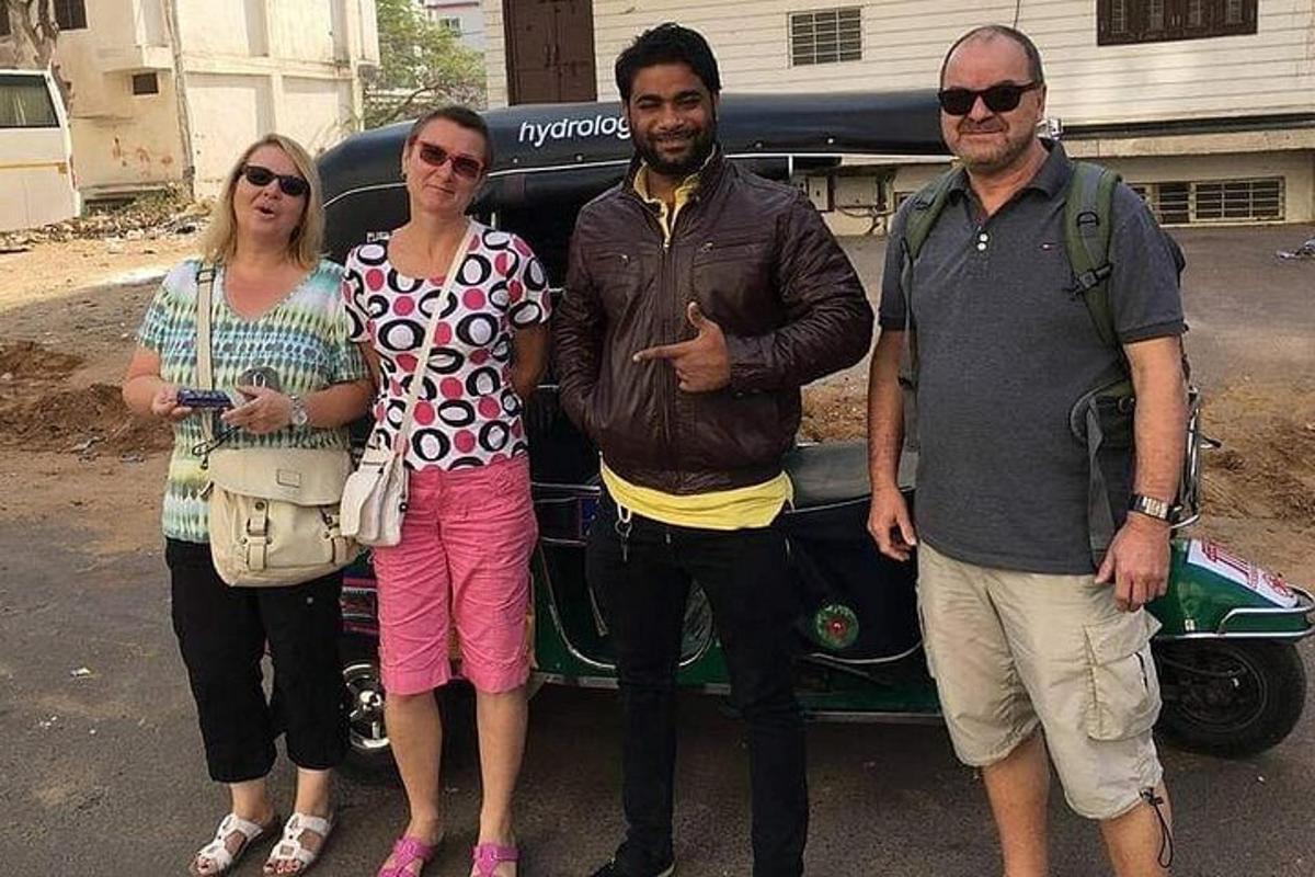 a group of three people standing in front of a car