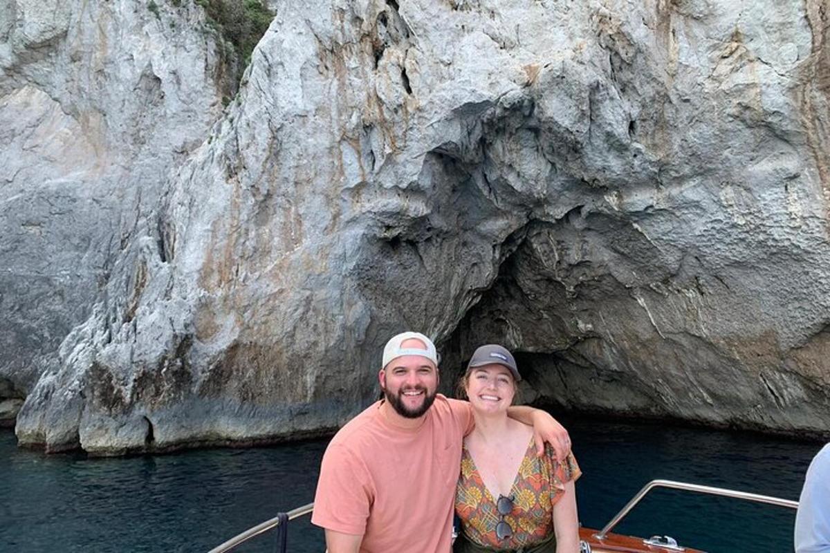 ein Mann und eine Frau auf einem Boot vor einer Höhle