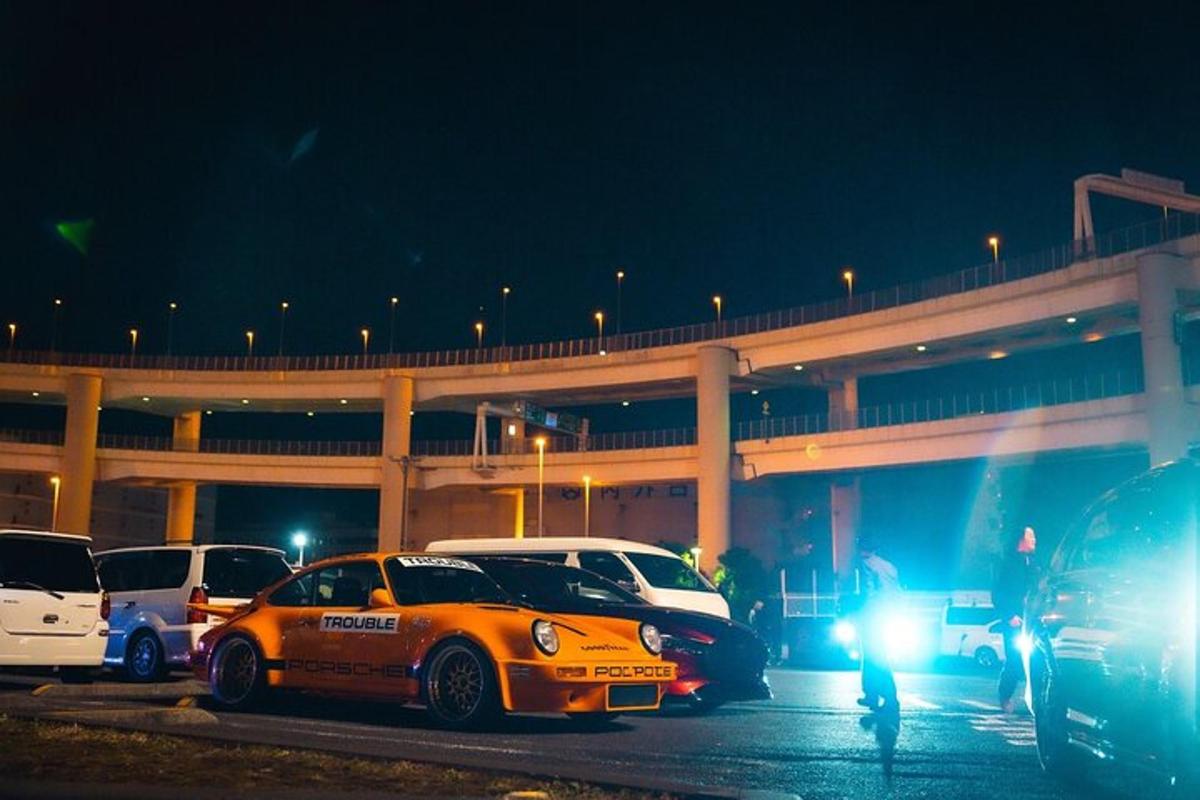 a group of cars parked in a parking lot at night