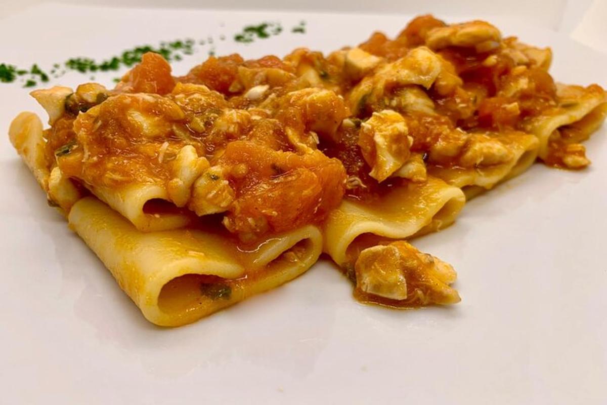 un pezzo di pasta con carne e formaggio su un piatto bianco