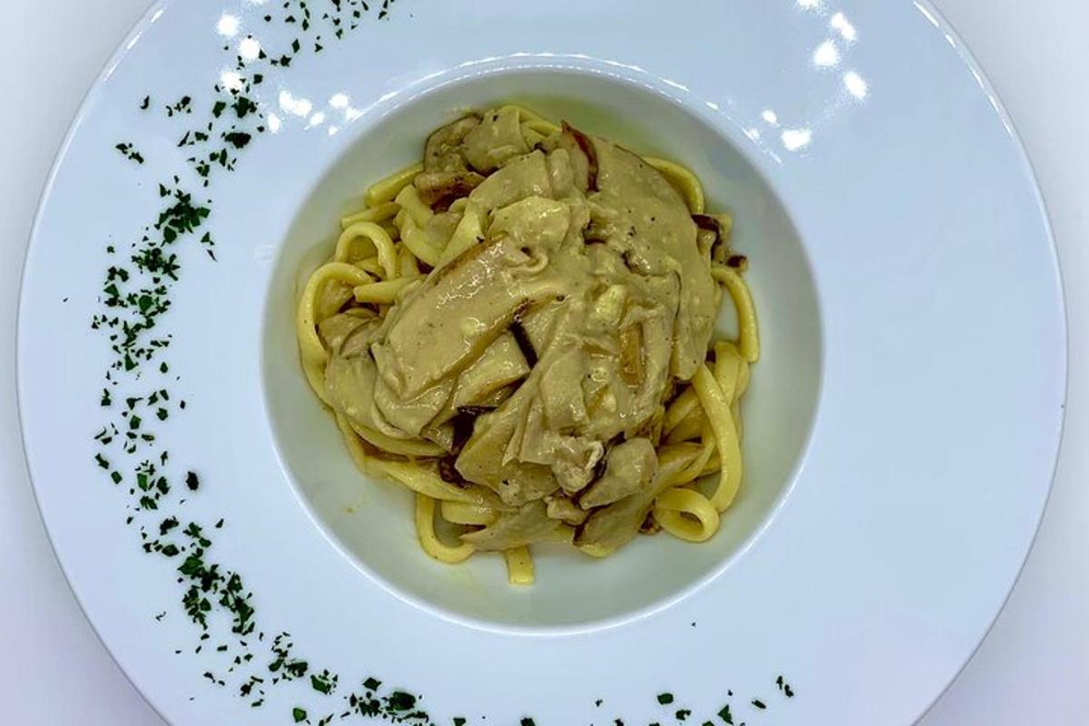 una ciotola di pasta con carne e salsa su un piatto