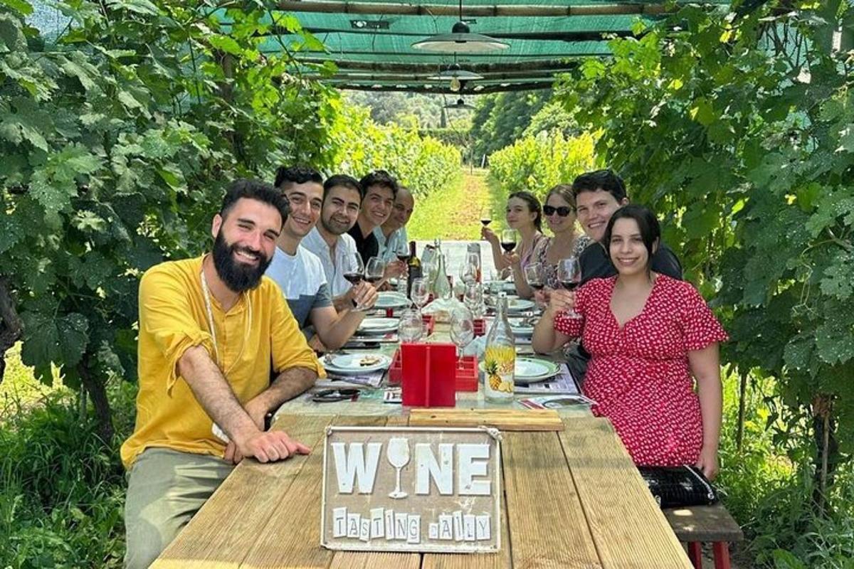 un gruppo di persone sedute a un tavolo con bicchieri di vino