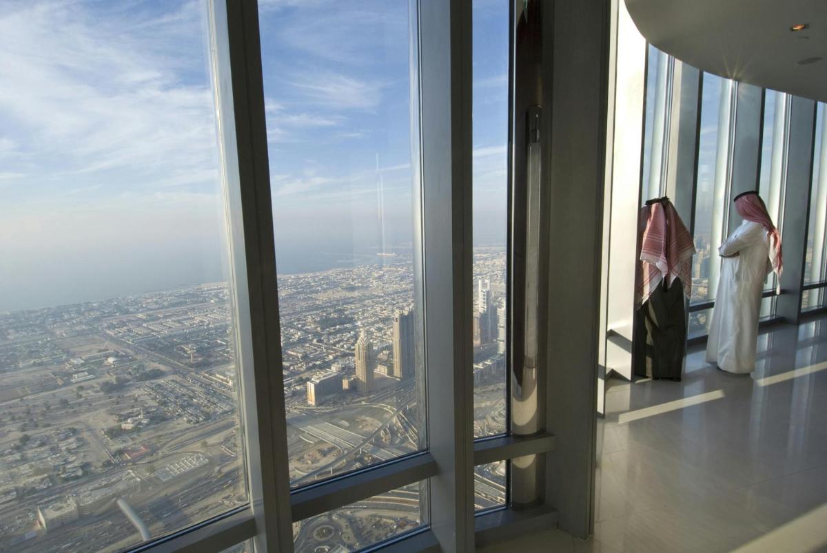 zwei Frauen stehen in einem Fenster und blicken auf eine Stadt