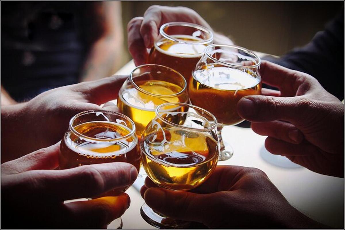 a group of people holding up glasses of beer