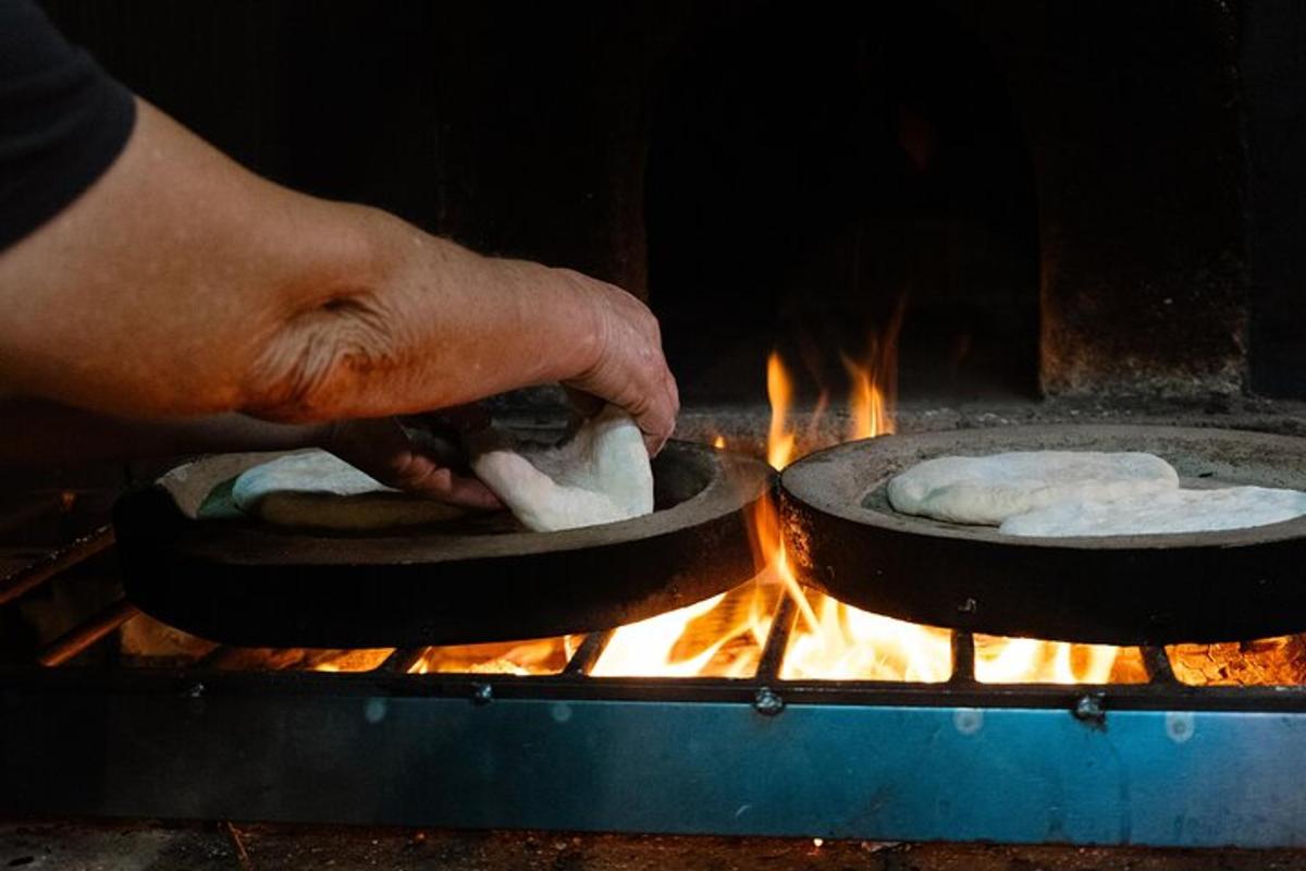 egy személy serpenyőkben, grillen főző ételt