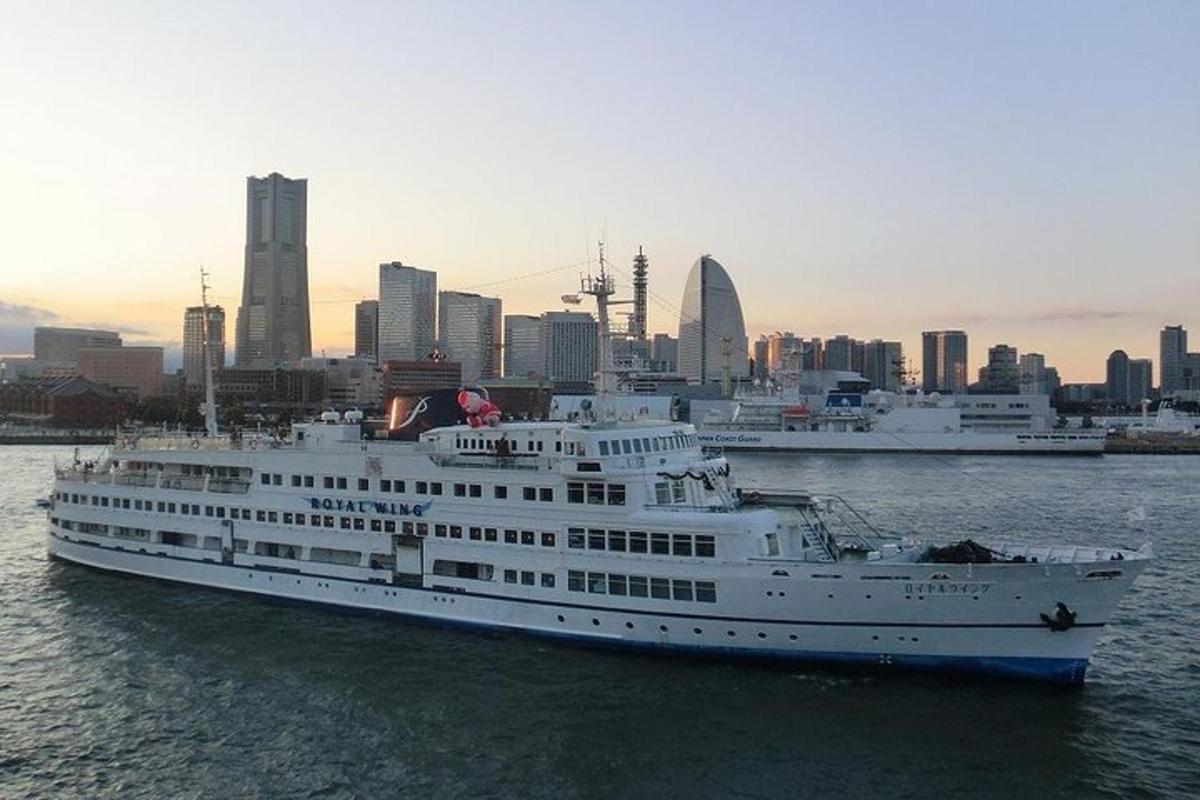 a cruise ship in the water with a city in the background