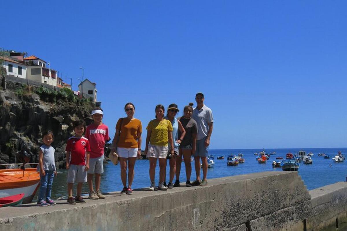 a group of people standing on a wall near the water