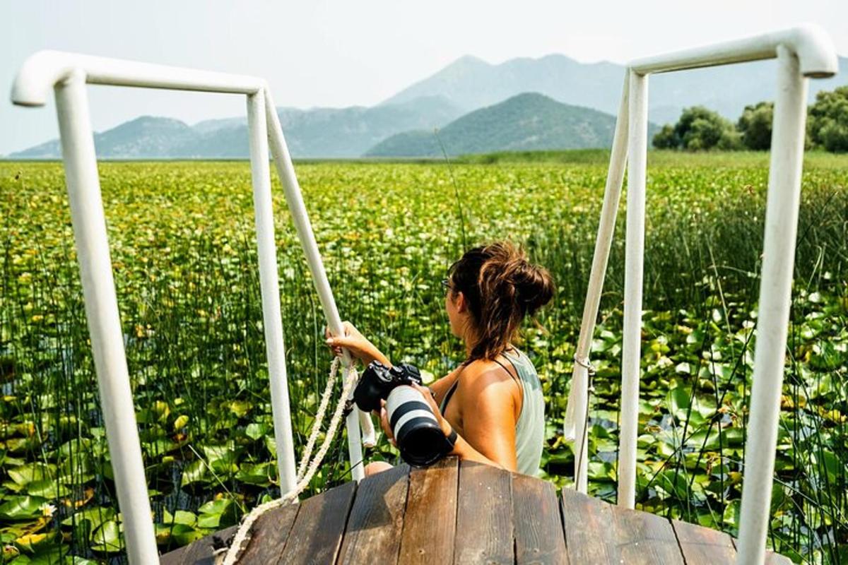 una donna con una macchina fotografica su una barca in un campo
