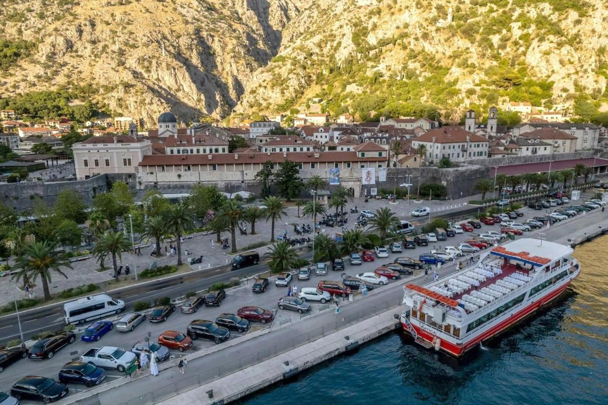 μια βάρκα στο νερό δίπλα σε ένα πάρκινγκ με αυτοκίνητα