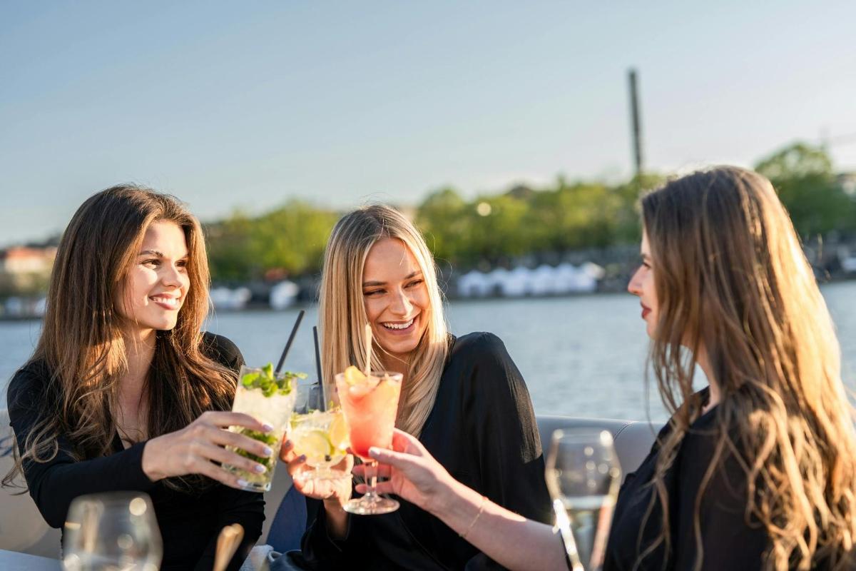 Tres mujeres sentadas en una mesa con bebidas