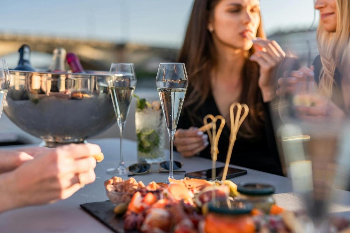 um grupo de pessoas sentadas à mesa com taças de vinho