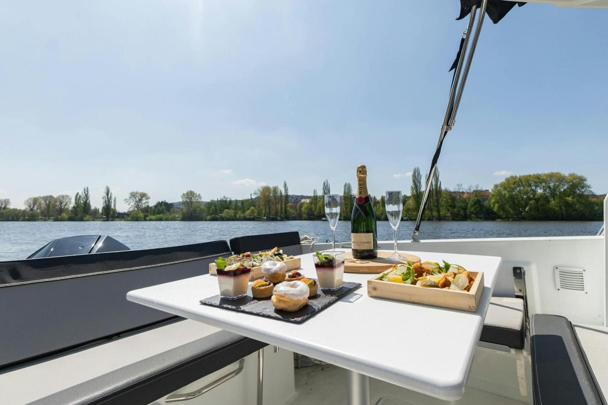 a table with food and a bottle of wine on a boat