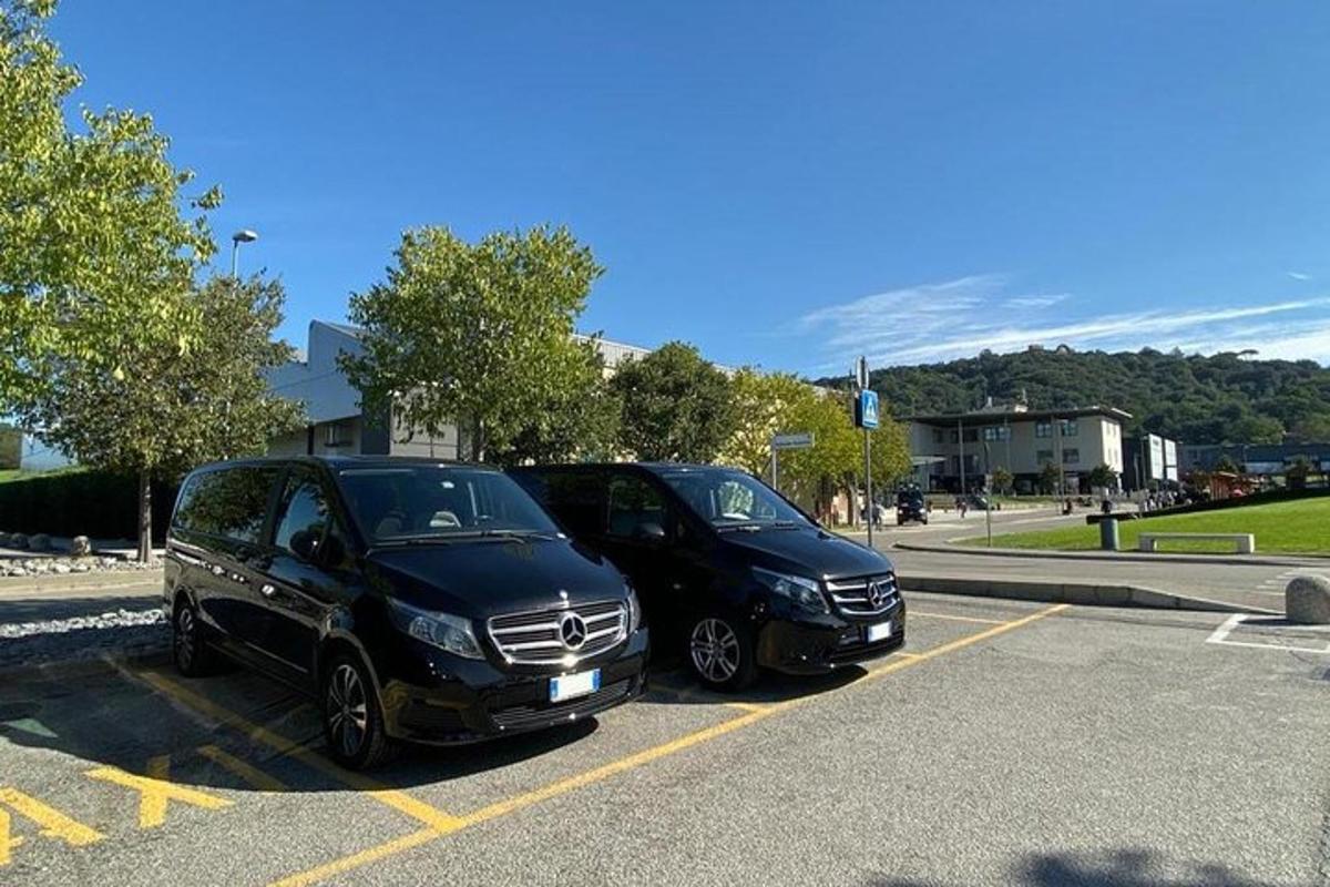 dvě černá auta zaparkovaná na parkovišti