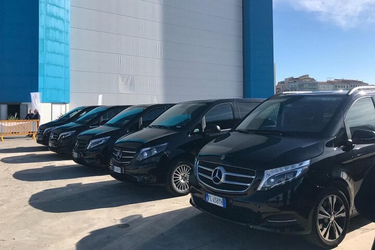 a row of black cars parked in a parking lot