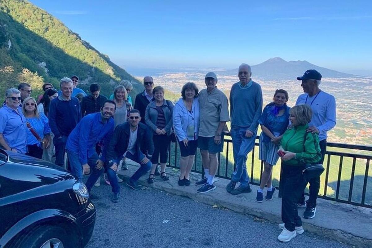 un grup de oameni care stăteau pe un gard lângă o mașină