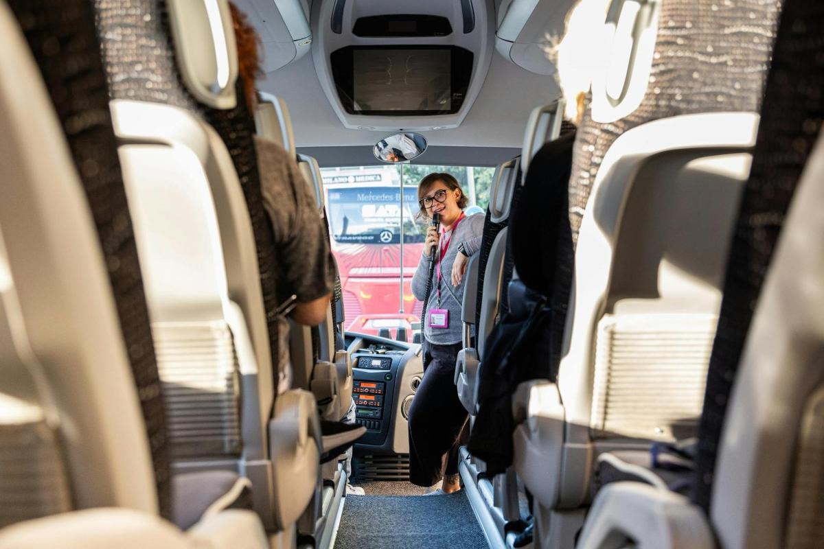 o femeie care stă în mijlocul interiorului unui autobuz