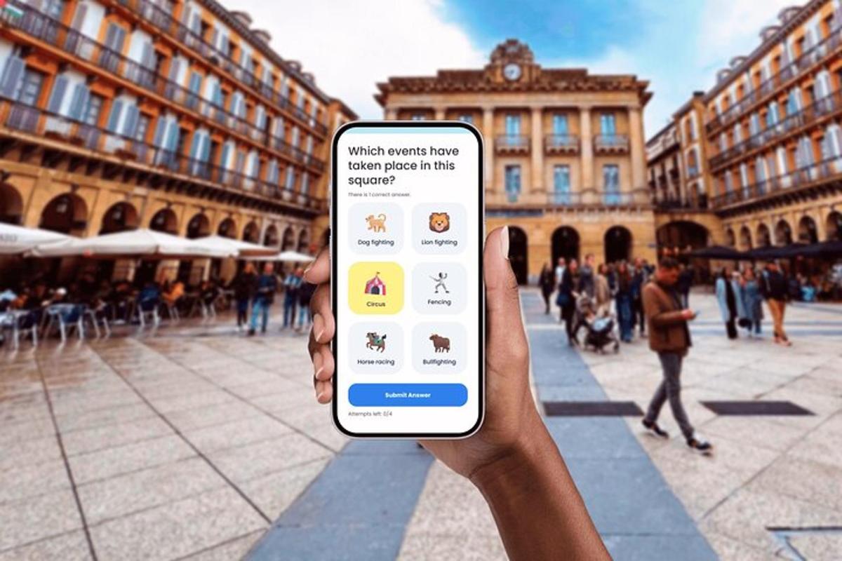 osoba držící mobilní telefon před budovou