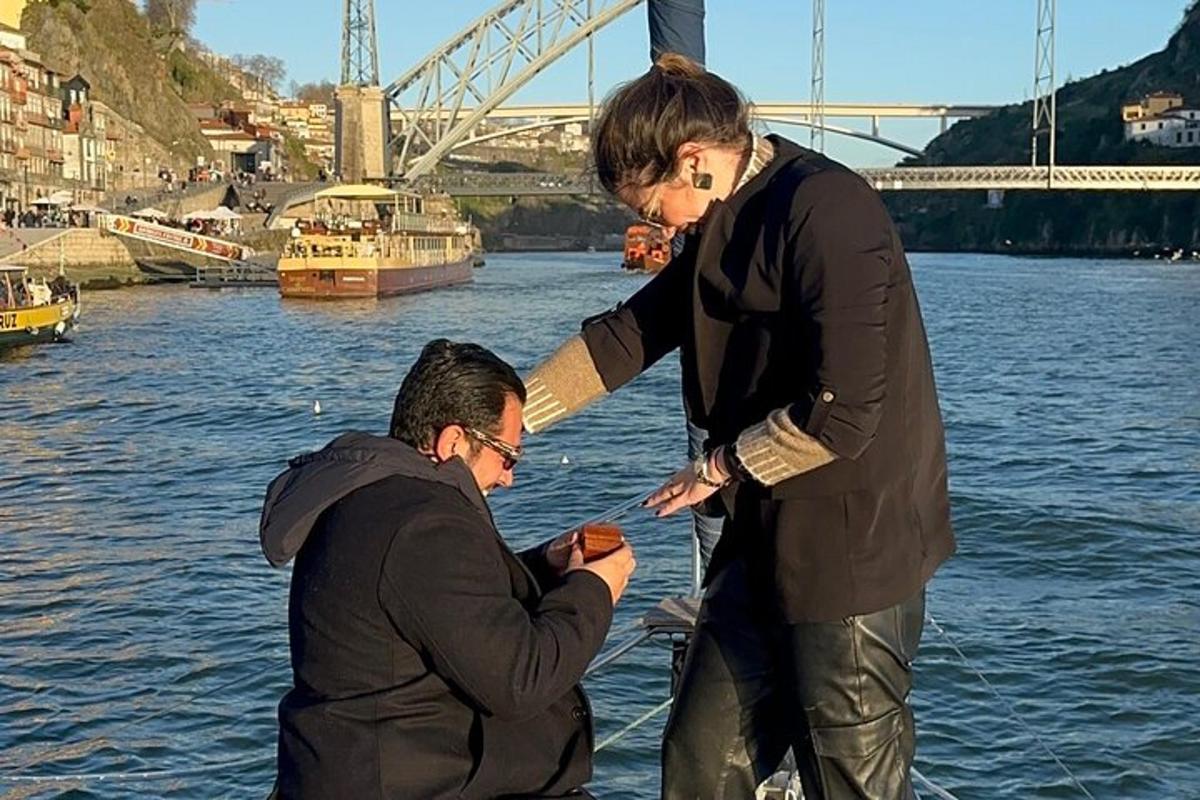 Dos hombres de pie junto al agua mirando un teléfono celular