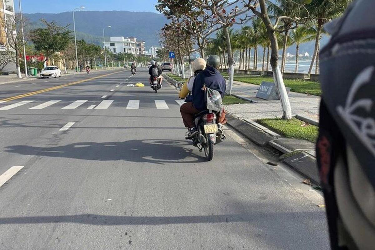 skupina lidí jedoucích na motorce po ulici