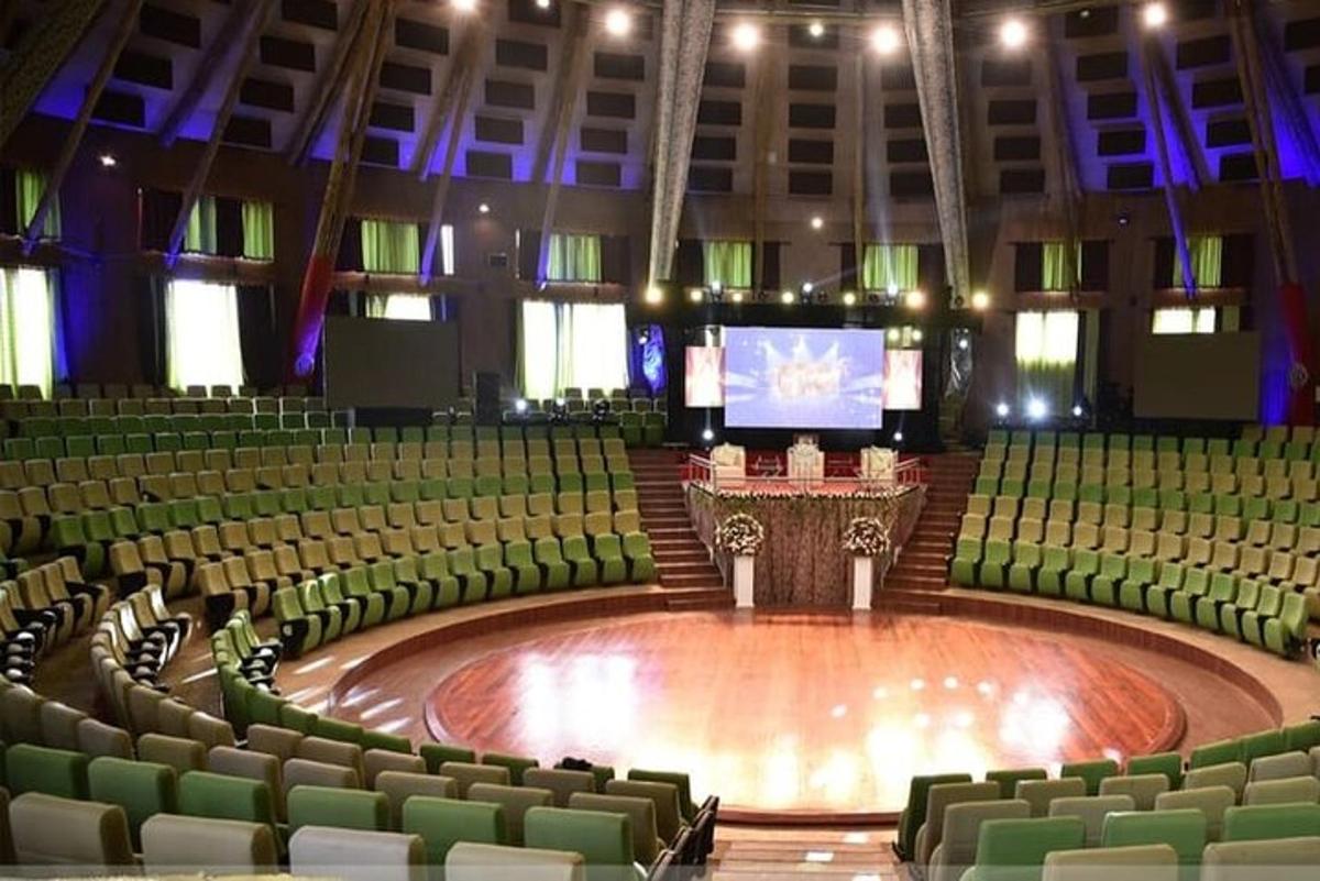 sebuah auditorium besar dengan kerusi hijau dan pentas