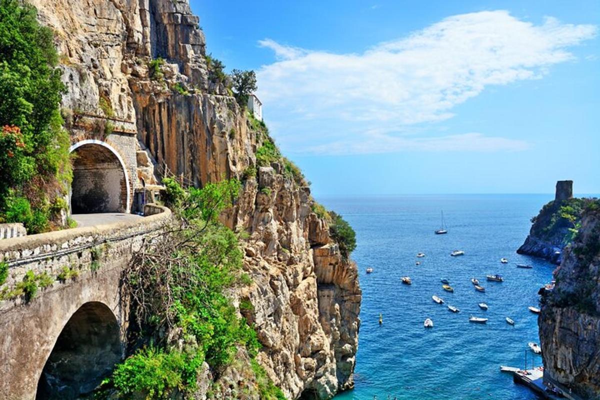 un ponte su una scogliera sopra l'acqua con barche
