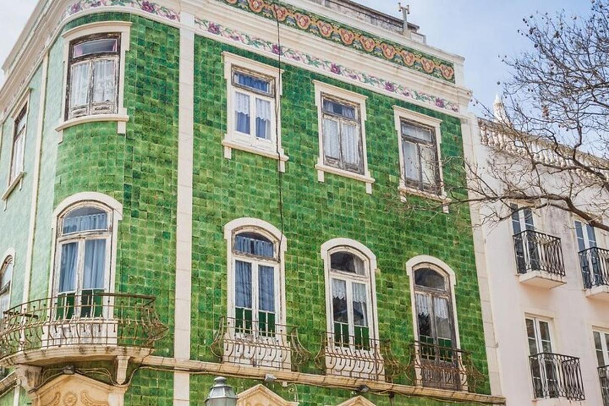 un edificio verde e bianco con finestre e balconi