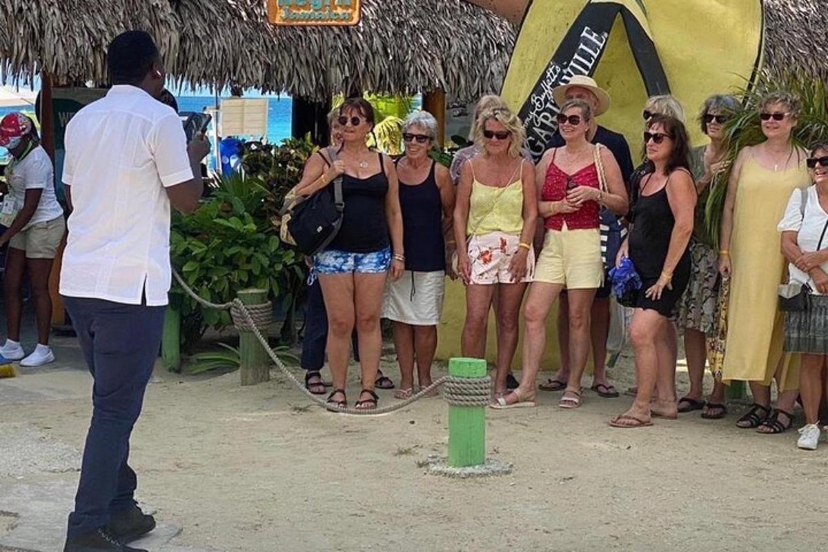 un uomo in piedi accanto a un gruppo di donne su una spiaggia