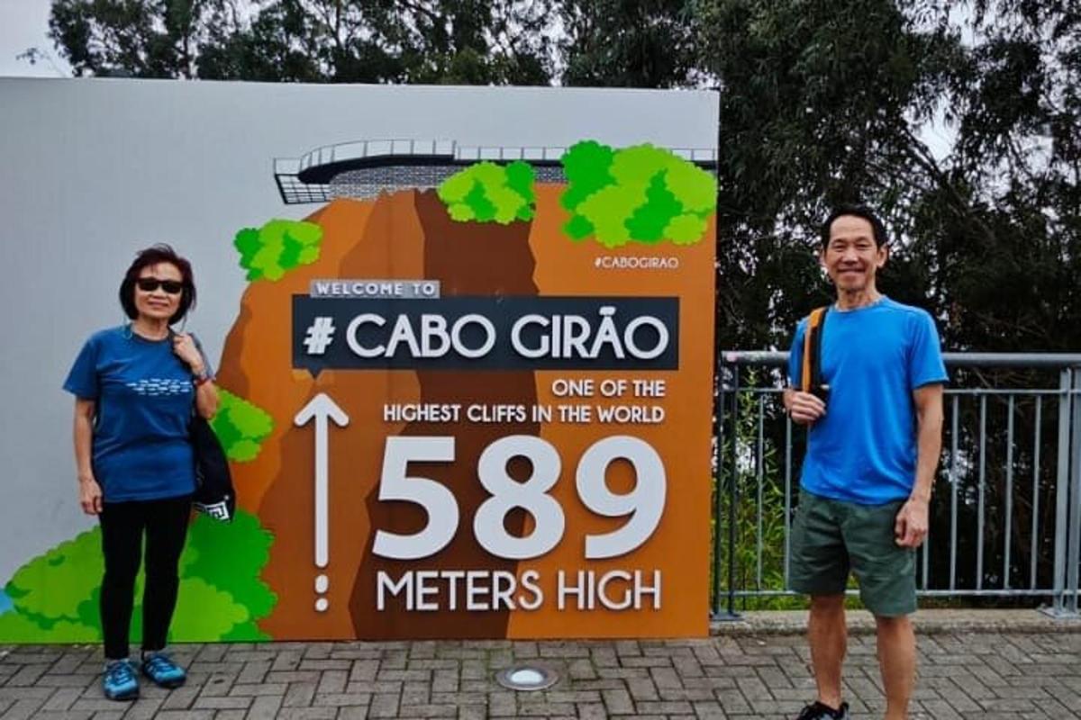 a man and a woman standing in front of a sign
