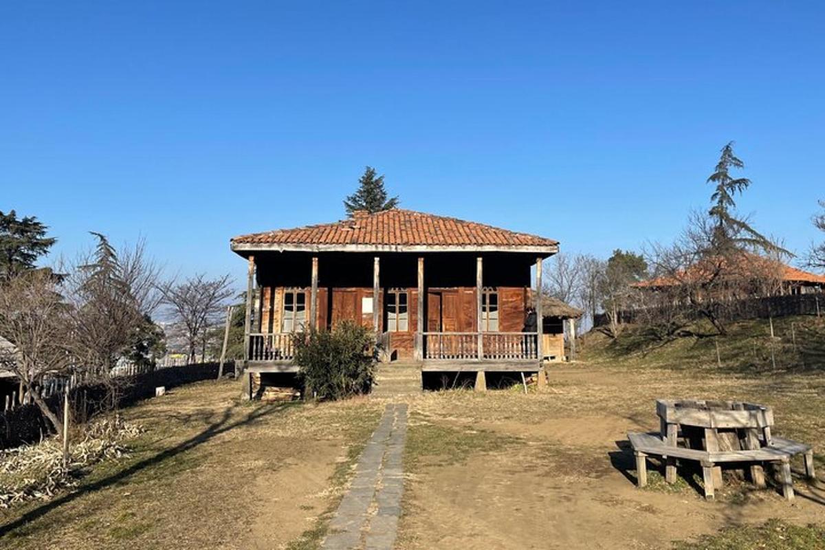 Una gran casa de madera con un banco delante de ella.