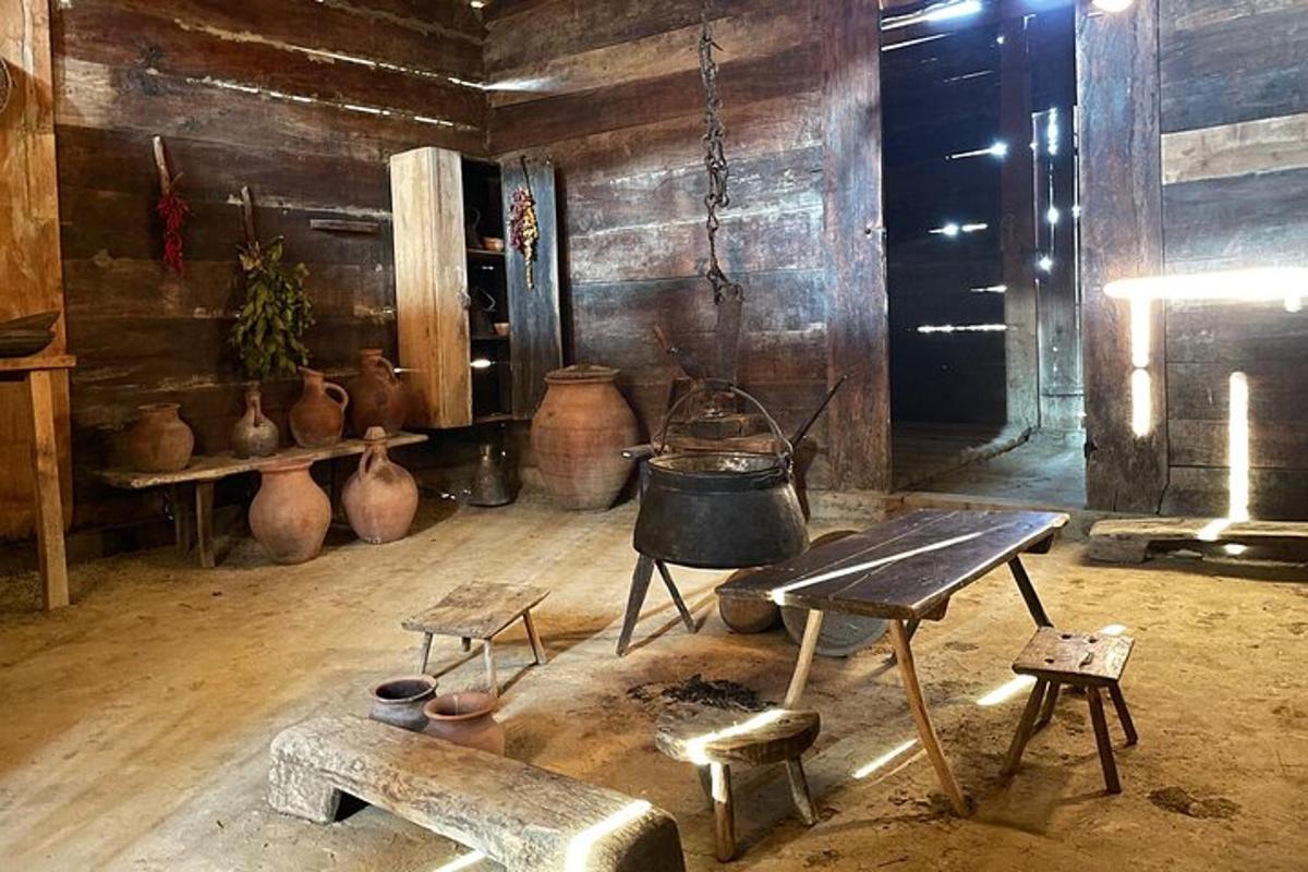 Una habitación con jarrones, un banco y una mesa.