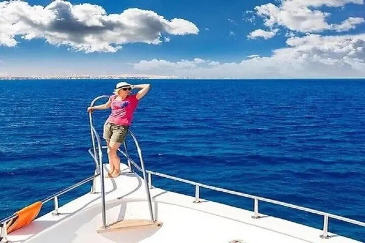una dona dempeus a la part davantera d'un vaixell a l'oceà
