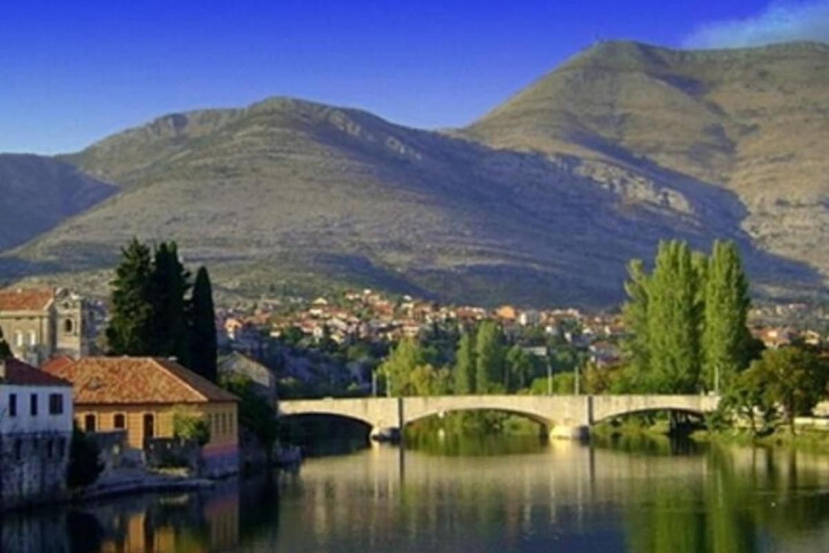 a bridge over a river with mountains in the background