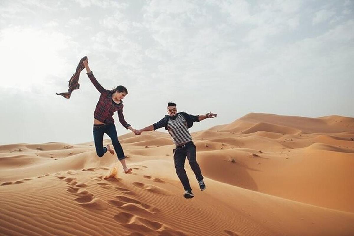 dues persones saltant a la sorra del desert